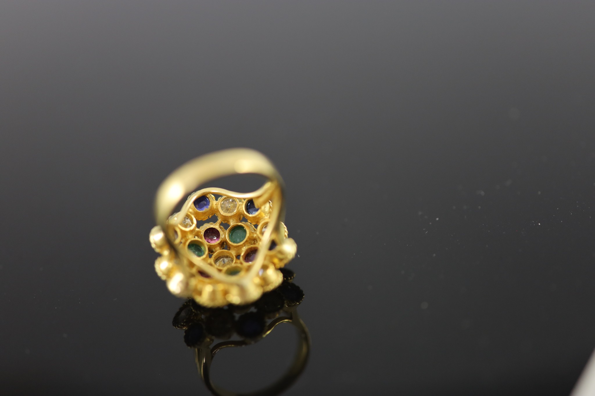 A continental gold (stamped 850) and multi gem set circular dress ring